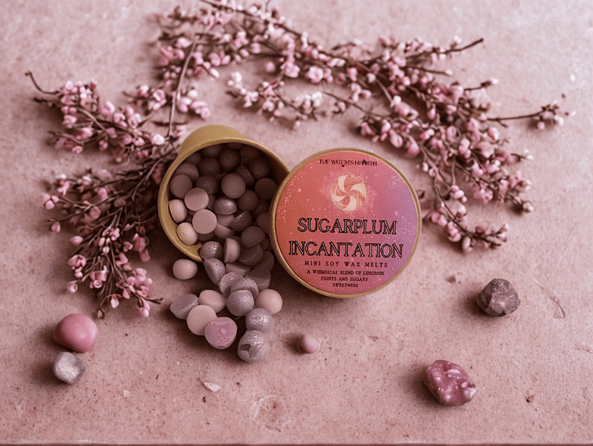 Tin of 'Sugarplum Incantation' wax melts with pink flowers on a textured surface