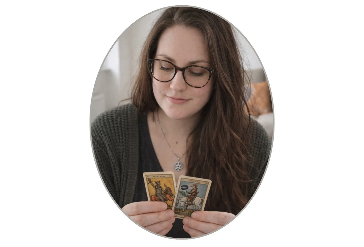 Woman holding two tarot cards in front of a plain background