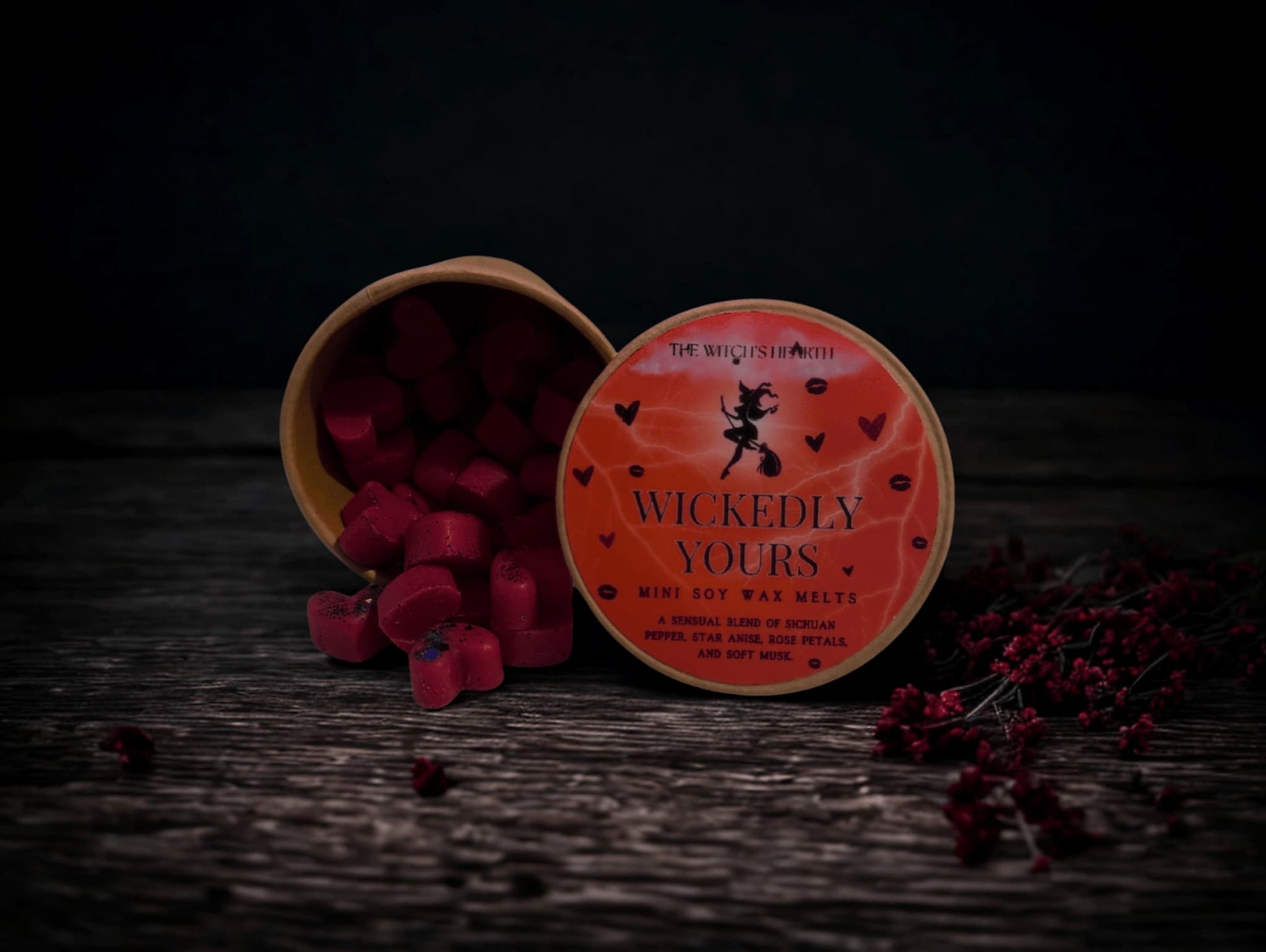 Wickedly Yours wax melts packaging on a dark wooden surface with red berries.
