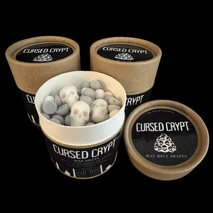 Cursed Crypt wax melt containers with skull-shaped melts on a black background