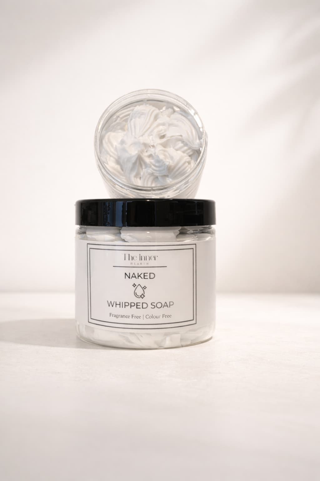 Naked whipped soap with light, fluffy white texture in a clear jar, fragrance free and colour free