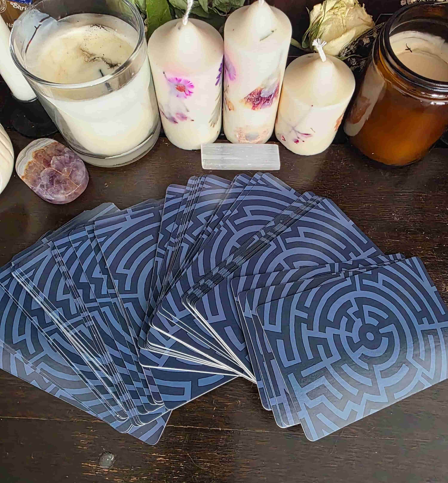 Blue patterned cards on a wooden surface with candles in the background