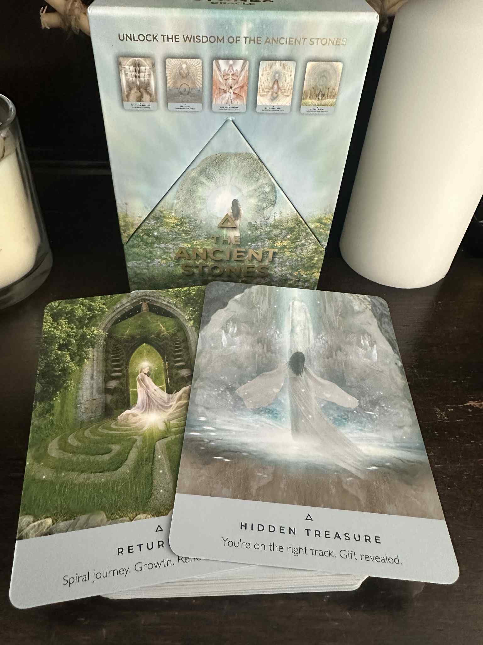 Set of tarot cards with nature-themed illustrations on a wooden surface.