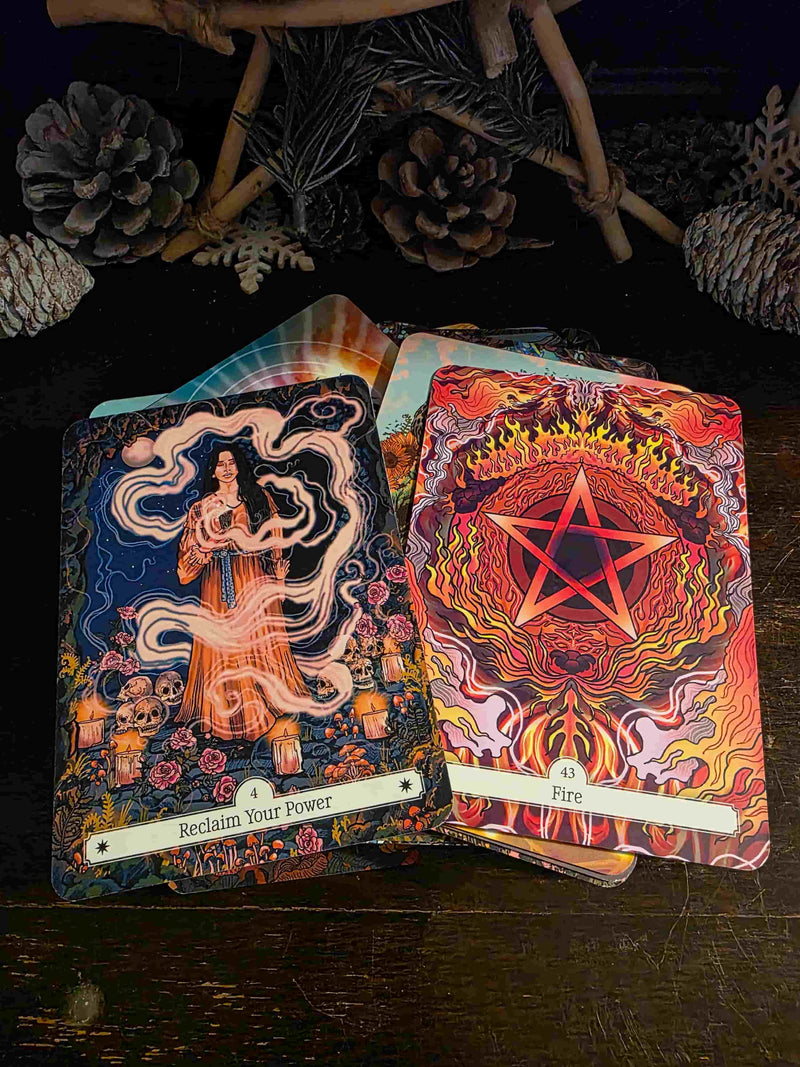 Two tarot cards on a dark surface with decorative elements