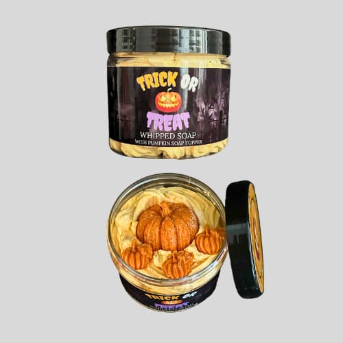 Jar of 'Trick or Treat' whipped soap with pumpkins on a gray background