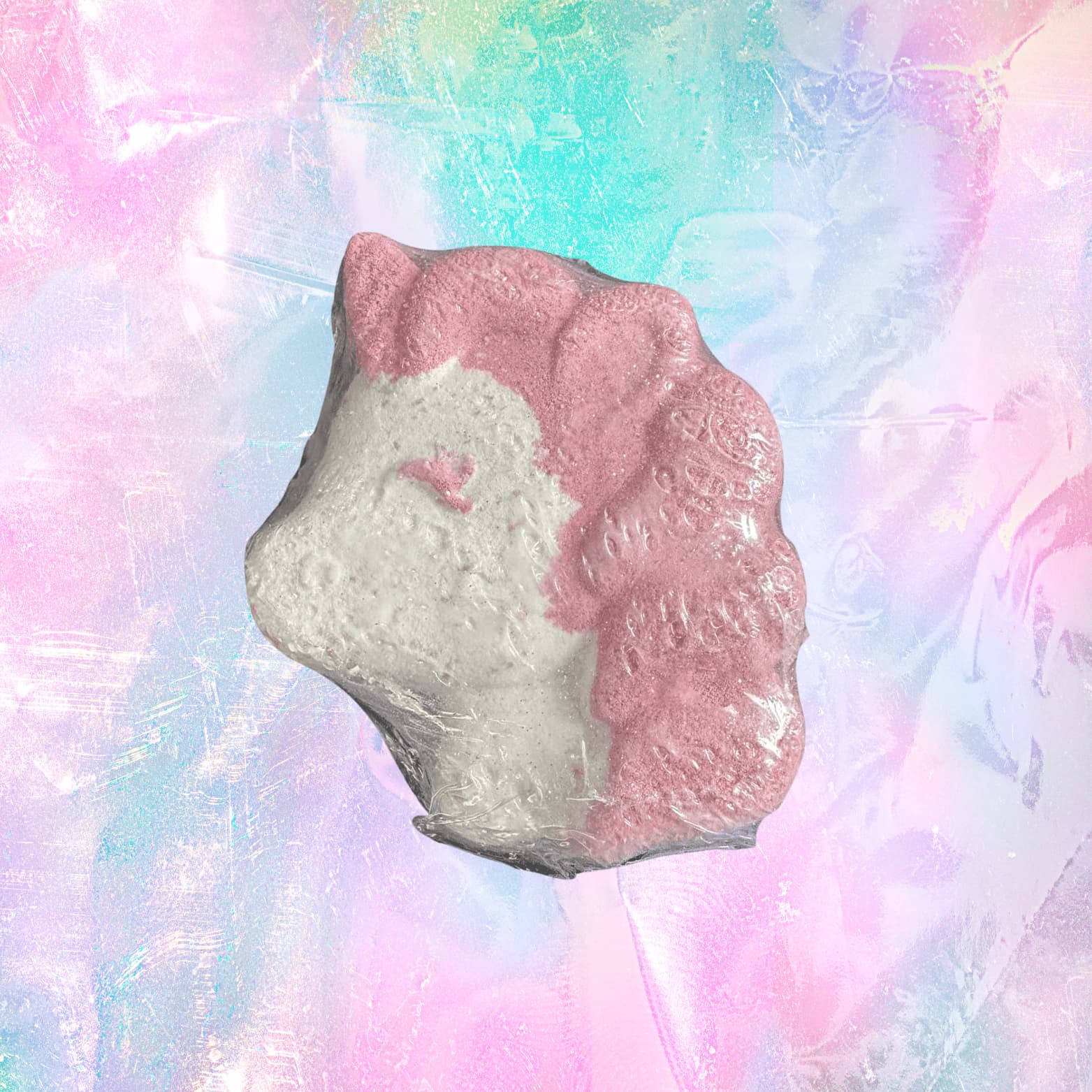 white and pink Bath bomb shaped like a unicorn with pink ears on a pastel, marbled background